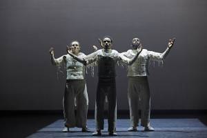 Three dancers on stage posed in unison