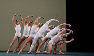 A group of athletic male dancers posed in synchronization